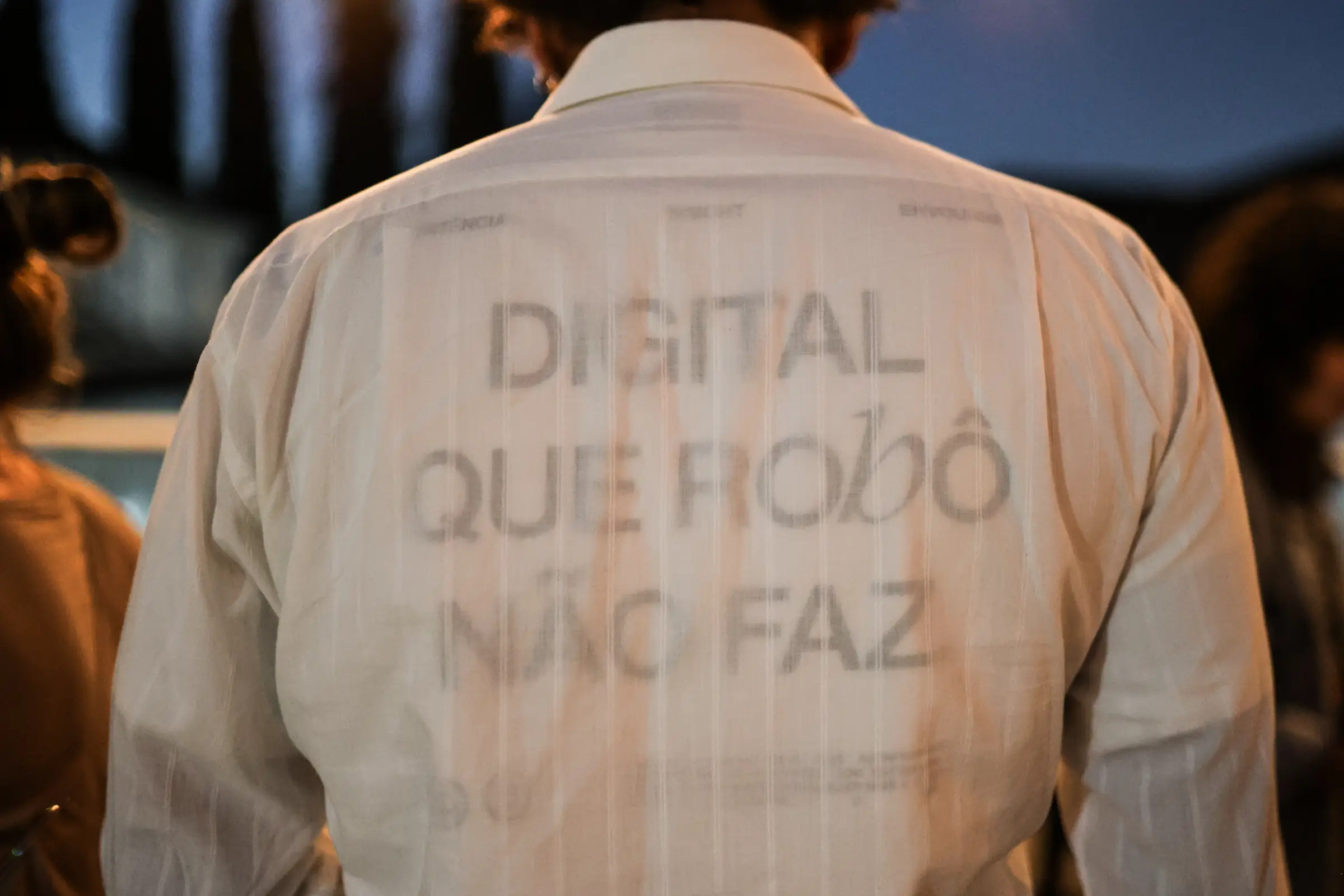 Pessoa de costas no DZ Day 2026, com a camiseta “Digital que robô não faz”